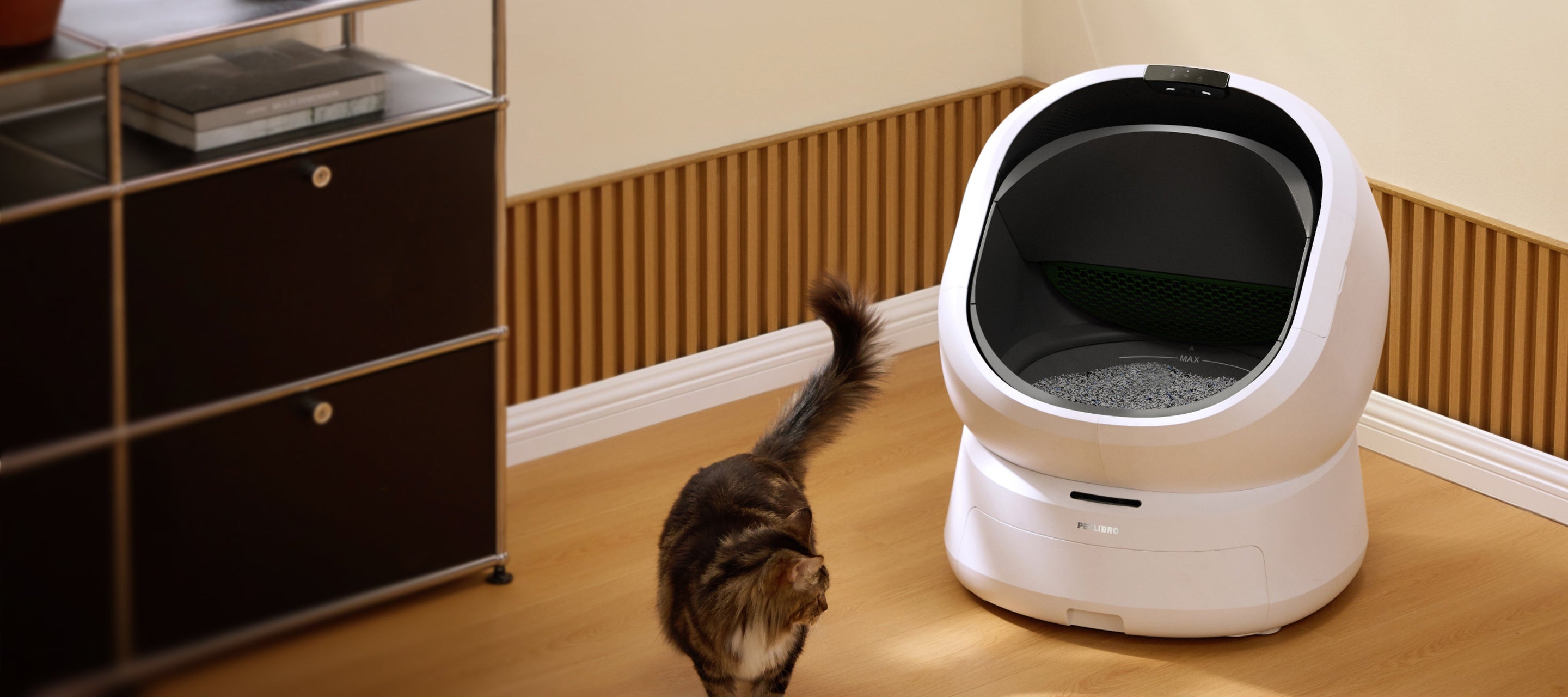 Petlibro PETLIBRO Katzentoilette neben Katze im Wohnzimmer; Brunnen und automatischer Futterspender fürs Haustier erwähnt