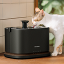 Petlibro PETLIBRO Brunnen: Katze trinkt am schwarzen Haustier-Wasserbrunnen; Katzentoilette und automatischer Futterspender erwähnt